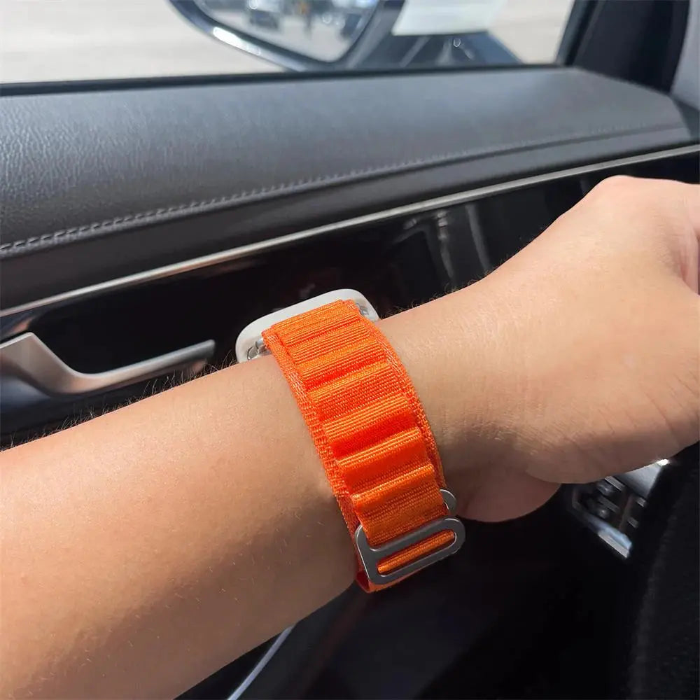 Orange rugged Alpine Loop band on wrist, perfect for athletes in fitness activities like running and hiking.