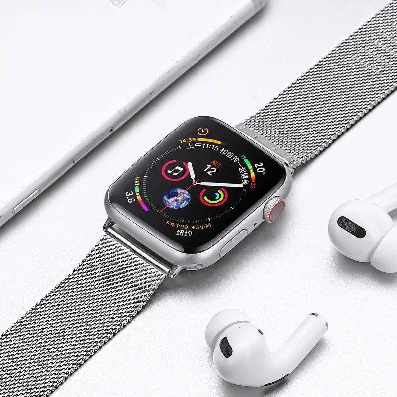Stylish Milanese strap with secure clasp on Apple Watch, alongside AirPods, showcasing a modern tech lifestyle.