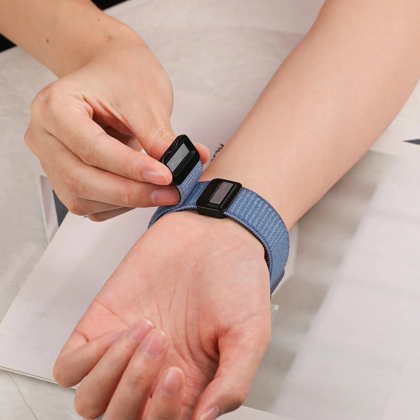 Adjusting a magnetic nylon sports band on a wrist, compatible with Samsung Galaxy Watch models.