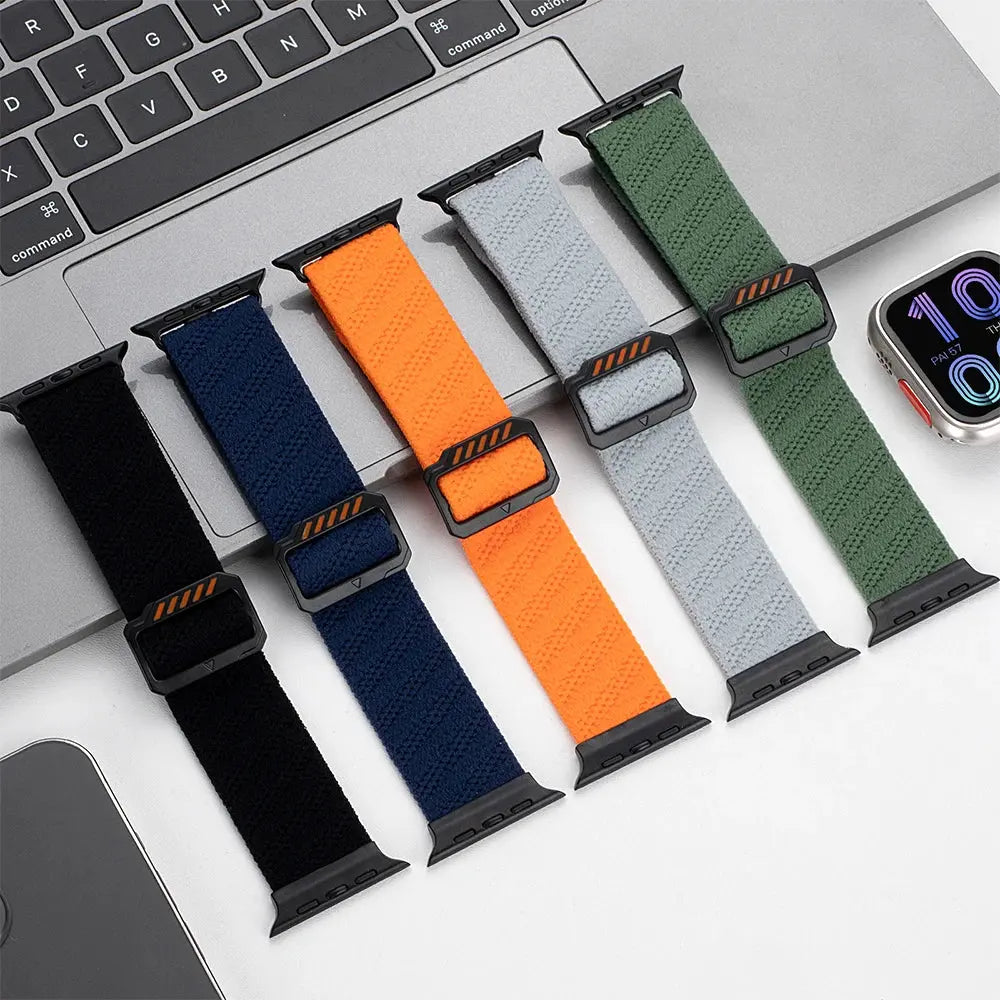 Colorful stretchy elastic bands for wrist comfort, featuring adjustable clasps, on a workspace with a laptop.