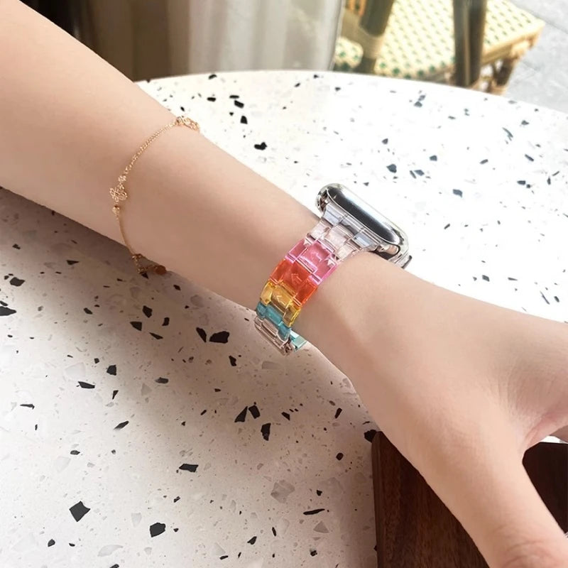Clear Apple Watch strap on wrist with colorful acrylic links, showcasing a modern and stylish accessory for any outfit.