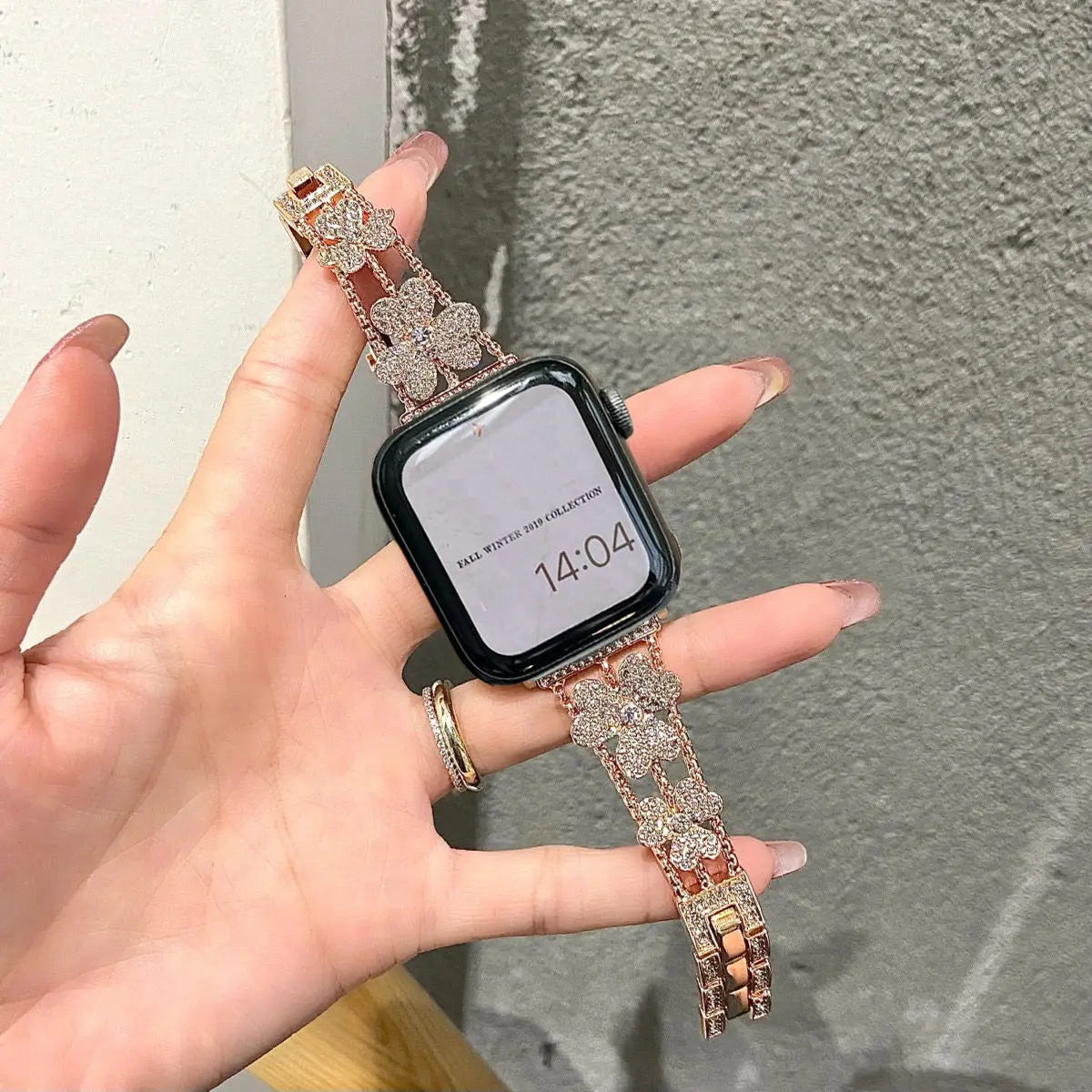 Gorgeous rhinestones bracelet for Apple Watch, featuring flower patterns and sparkling stones, held in hand.