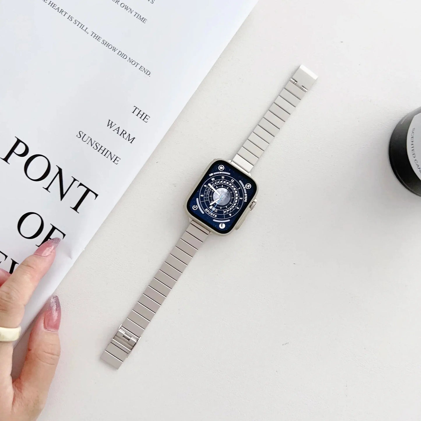 Elegant stainless steel luxury starlight bracelet for Apple Watch on a flat surface with decorative items.