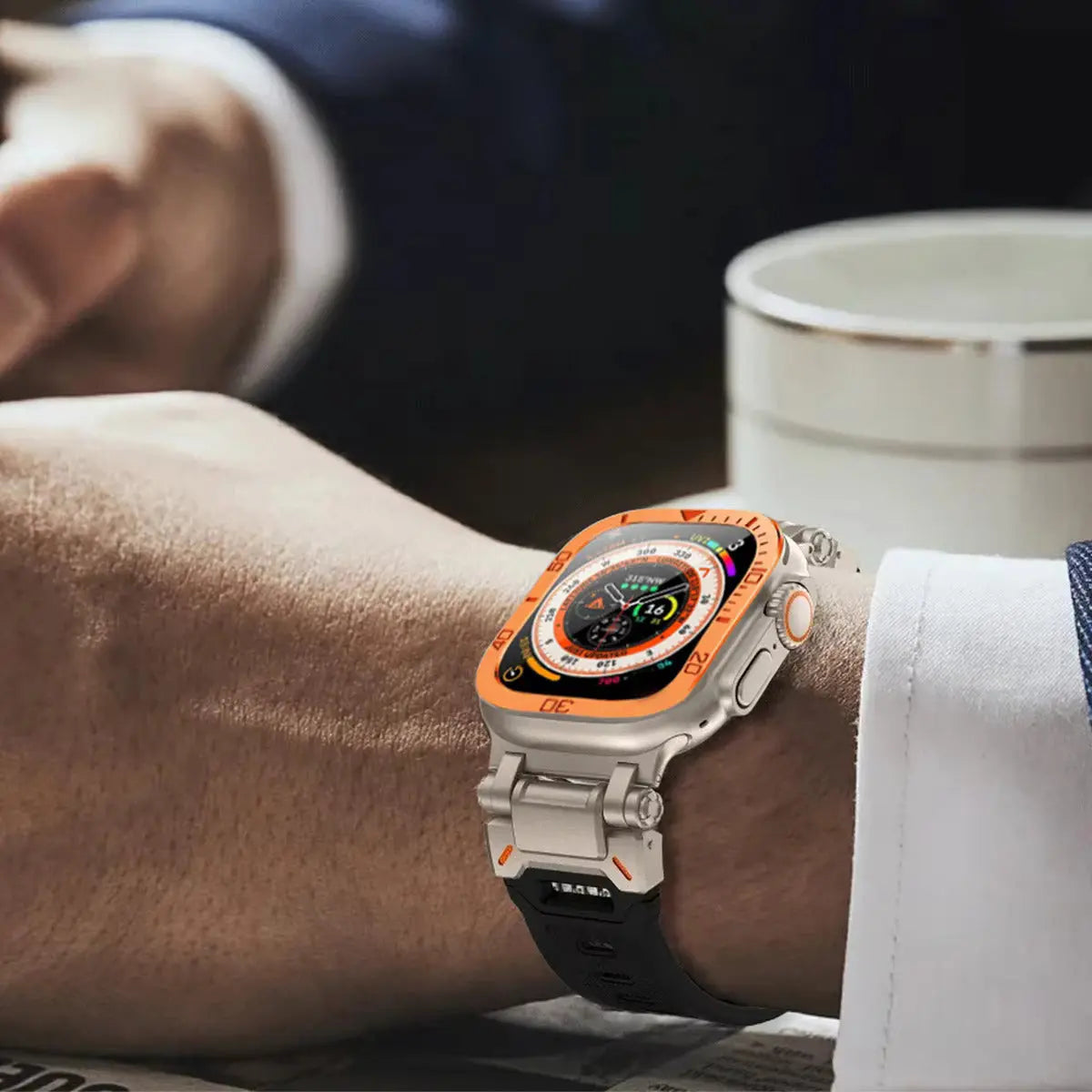 Close-up of a man's wrist showcasing an orange Rugged Silicon Band Apple Watch Ultra with a sleek metal case.