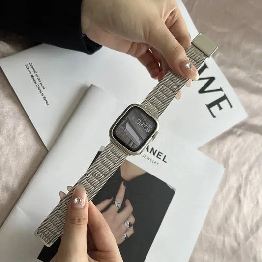 Modern Milanese Bracelet showcased on a wrist, pairing stylishly with an Apple Watch, set on a chic fashion magazine backdrop.