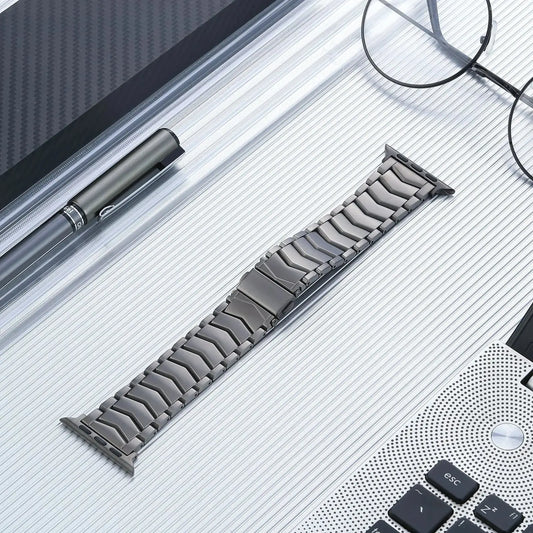 Premium stainless steel titanium finish Apple Watch Ultra band on a sleek surface.