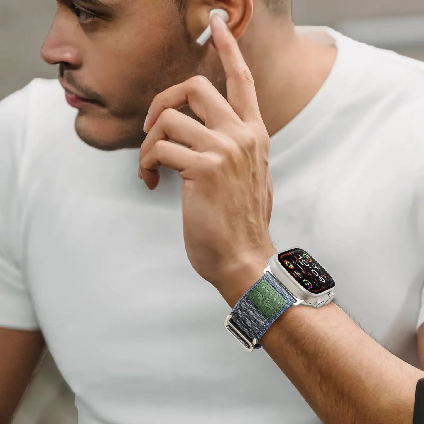 Man wearing Royal Alpine Loop band for Apple Watch, enjoying style and comfort with wireless earbuds.