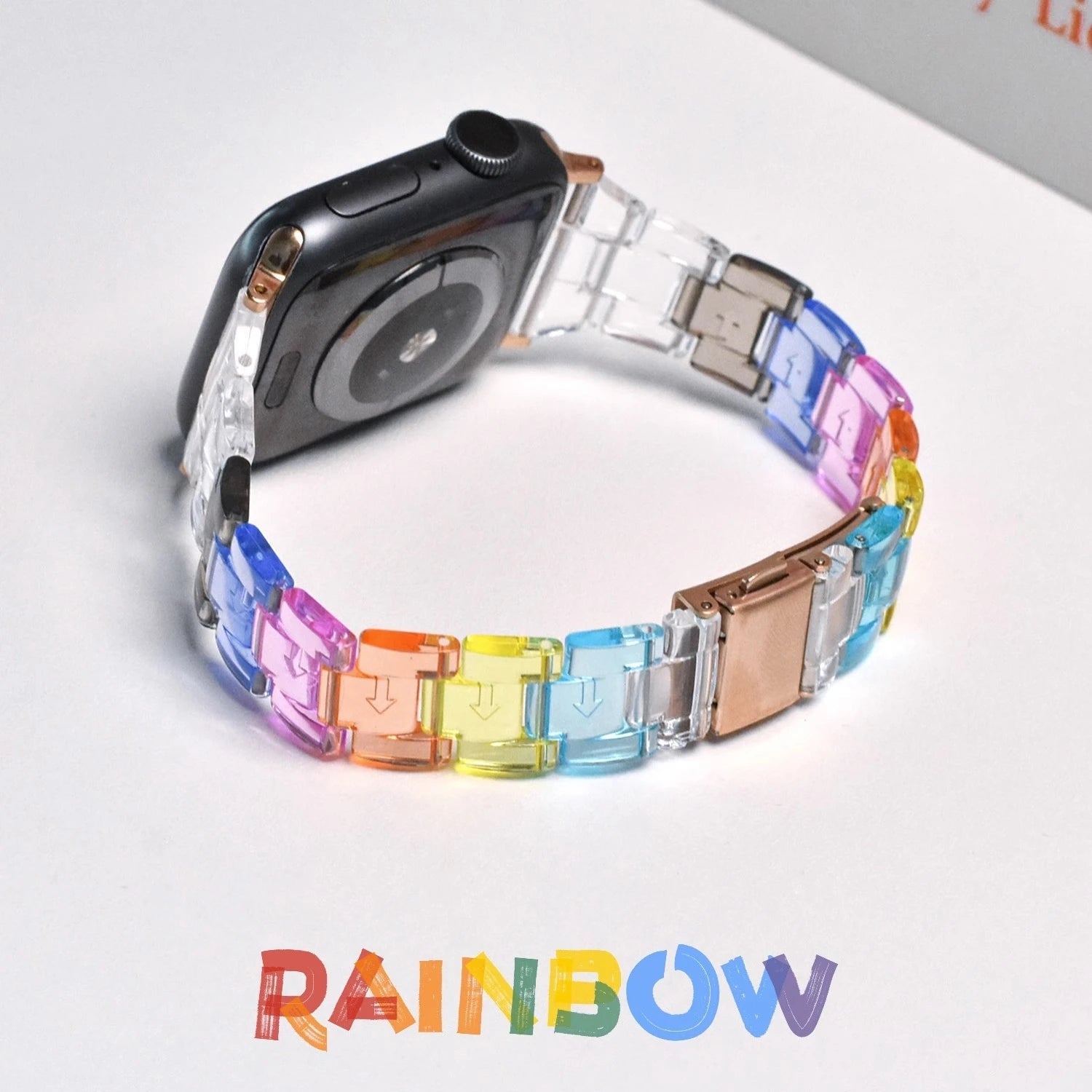 Stylish clear Apple Watch strap in rainbow colors with butterfly clasp, perfect for a modern look.