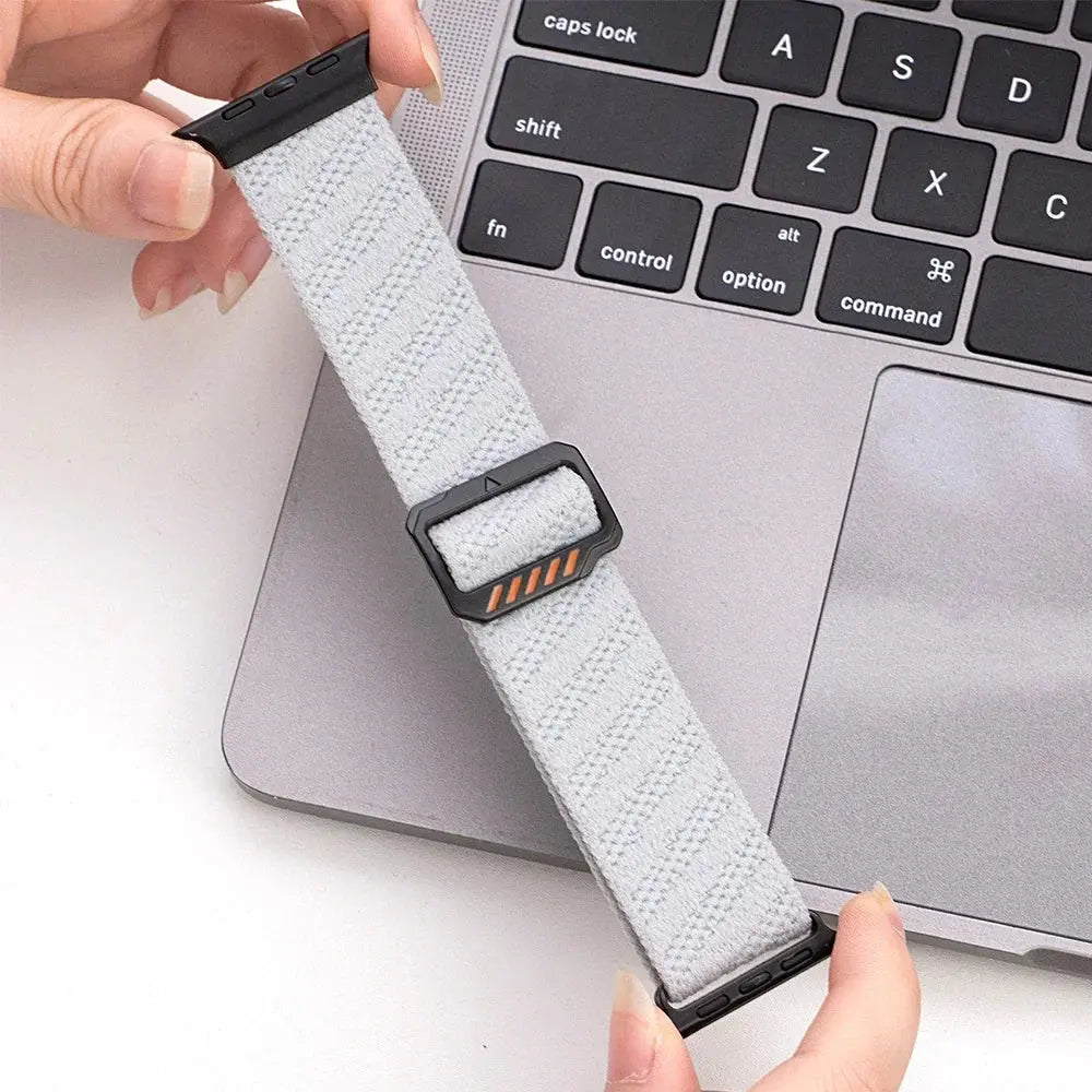 Dennis, The Stretchy Elastic Band in soft gray, featuring adjustable clasp for a customized fit on a laptop keyboard.
