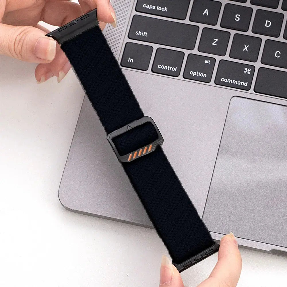 Dennis, The Stretchy Elastic Band in black, adjustable clasp for a comfortable custom fit on a laptop desk.