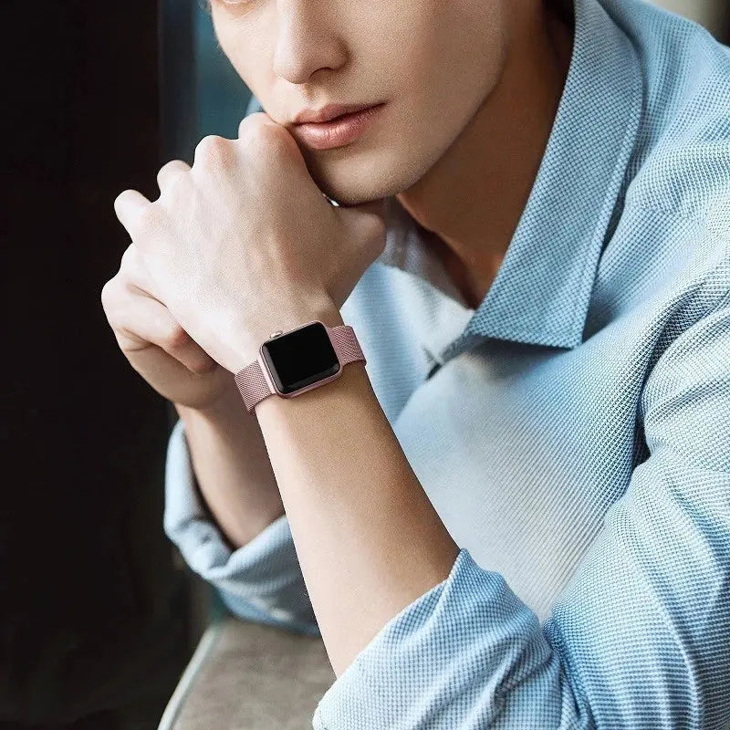 A stylish man wearing an Apple Watch with an upgraded Milan Loop band, showcasing comfort and elegance.