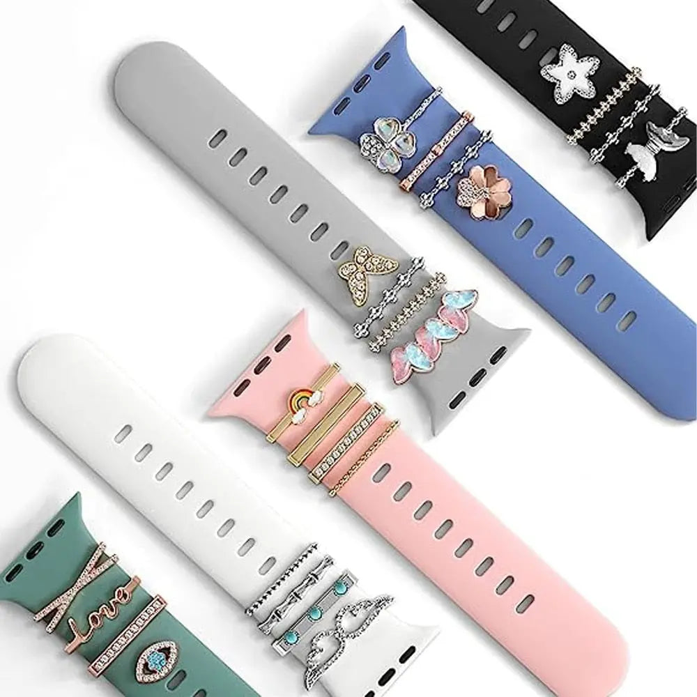 Colorful Apple Watch bands adorned with decorative jewelry charms in various designs and polished finishes.
