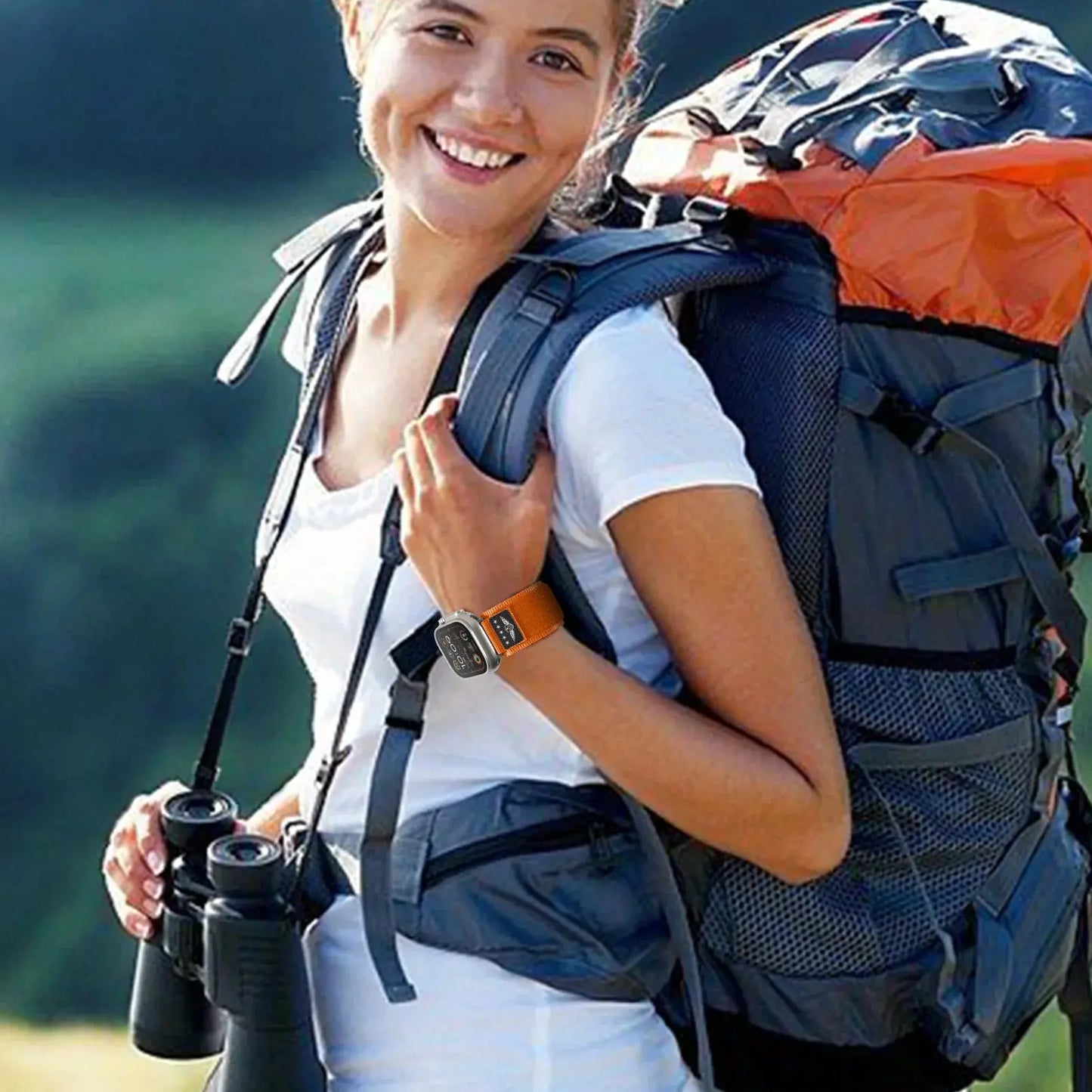 Woman wearing Sport Woven Nylon Band with USA Flag on Apple Watch, hiking with a backpack and binoculars.
