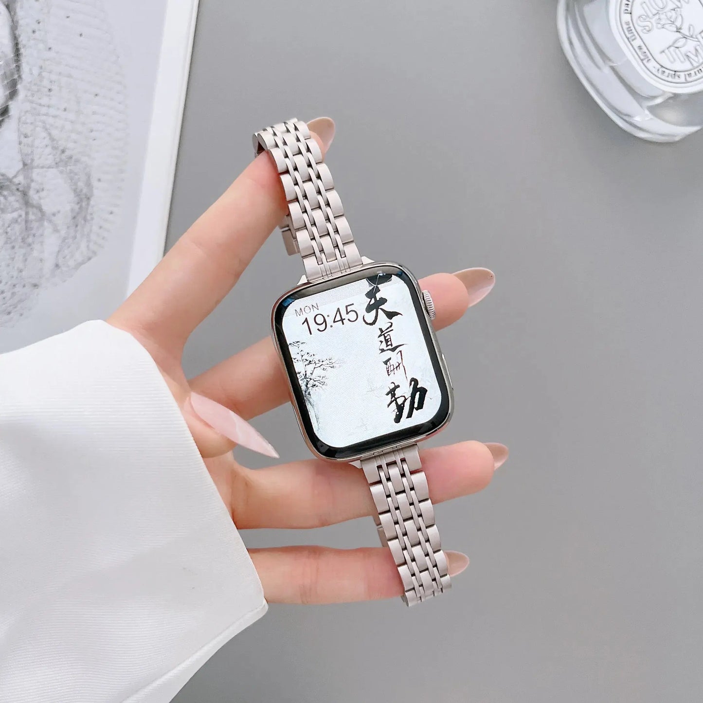 Elegant stainless steel Apple Watch bracelet showcasing a starlight color with a bold design and adjustable strap.
