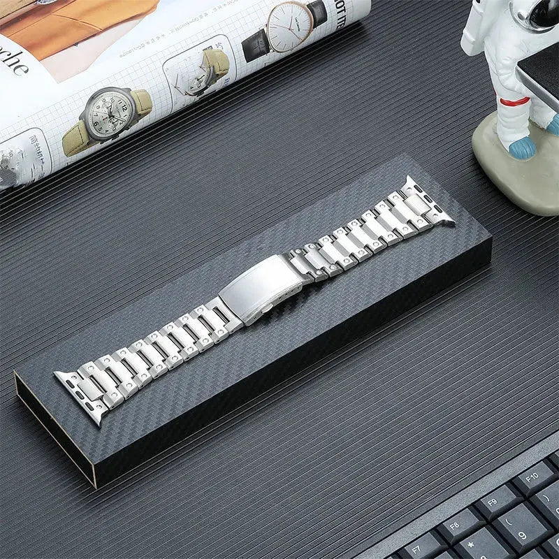 Glossy titanium bracelet for Apple Watch, showcasing premium stainless steel and secure folding buckle in elegant presentation.