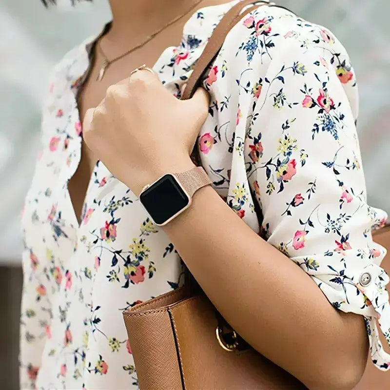 Slim Milanese loop iWatch band in premium stainless steel, styled with a floral shirt for a professional look.