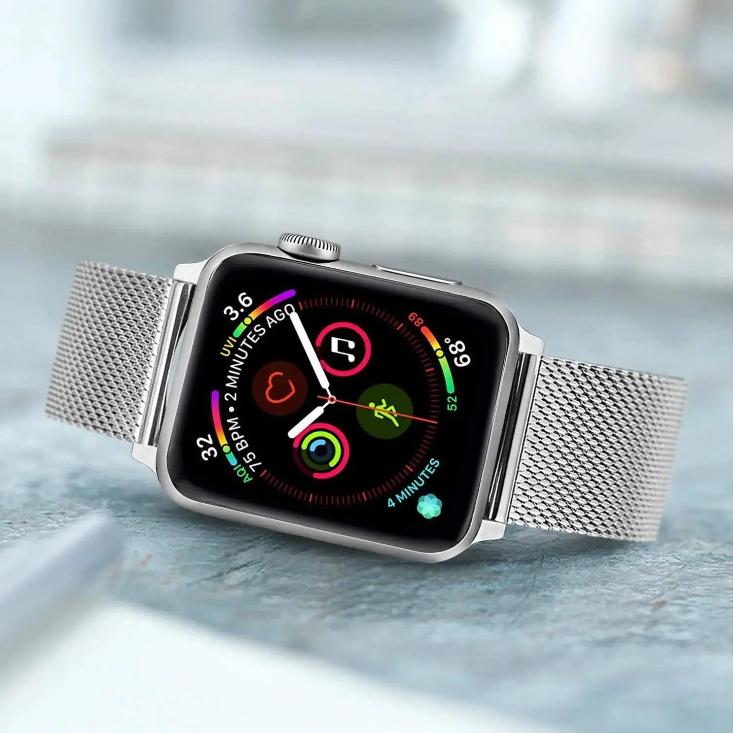 Apple Watch with Milanese strap featuring a secure clasp and colorful watch face, set on a stylish surface.