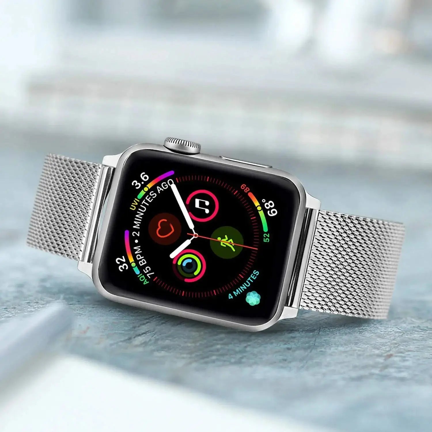 Apple Watch with Milanese strap featuring a secure clasp and colorful watch face, set on a stylish surface.
