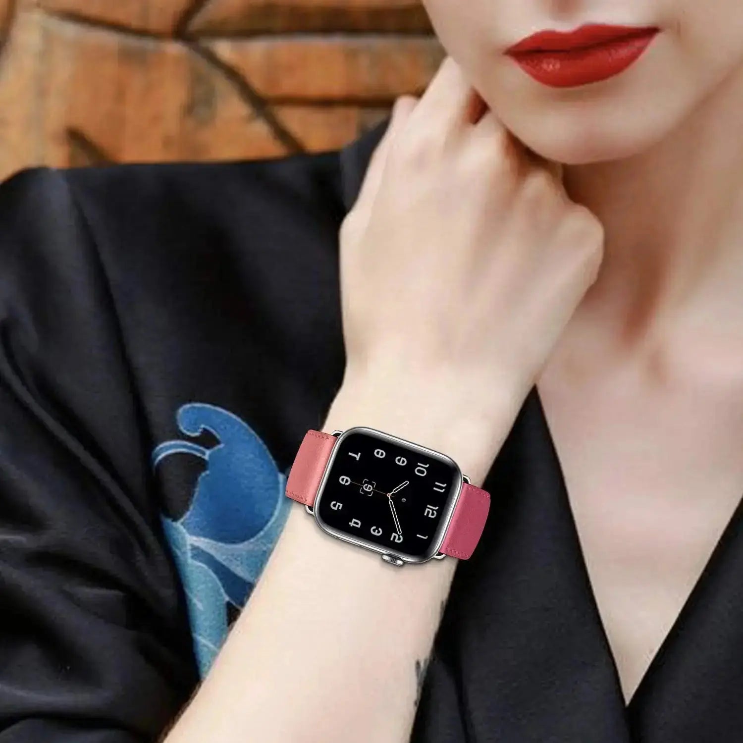 Elegant woman wearing an Apple watch with a Classic Single Tour leather strap in pink, showcasing its stylish design.