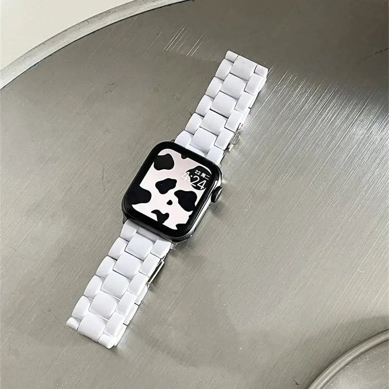 Clear Slim Acrylic Apple Watch Bracelet on a metallic surface, showcasing a stylish cow print watch face.