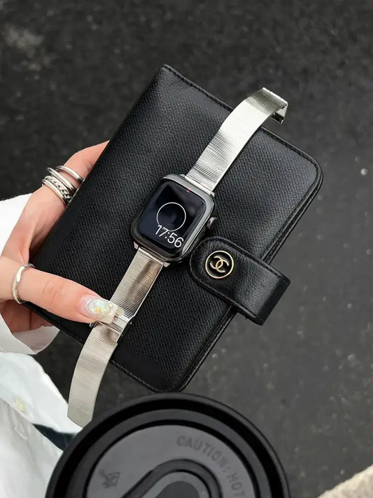 Glossy Stainless Steel Apple Watch Band – Slim Women’s Metal Strap (38–49mm) styled with chic black wallet and coffee.