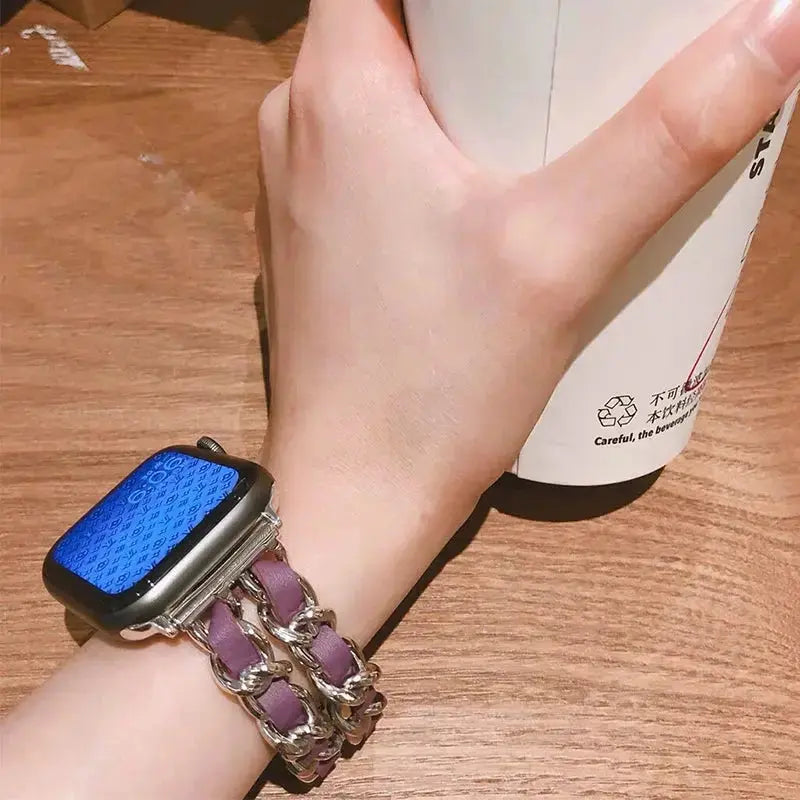 Luxury stainless steel chain bracelet with purple leather strap and Apple Watch, stylish accessory with rhinestones.