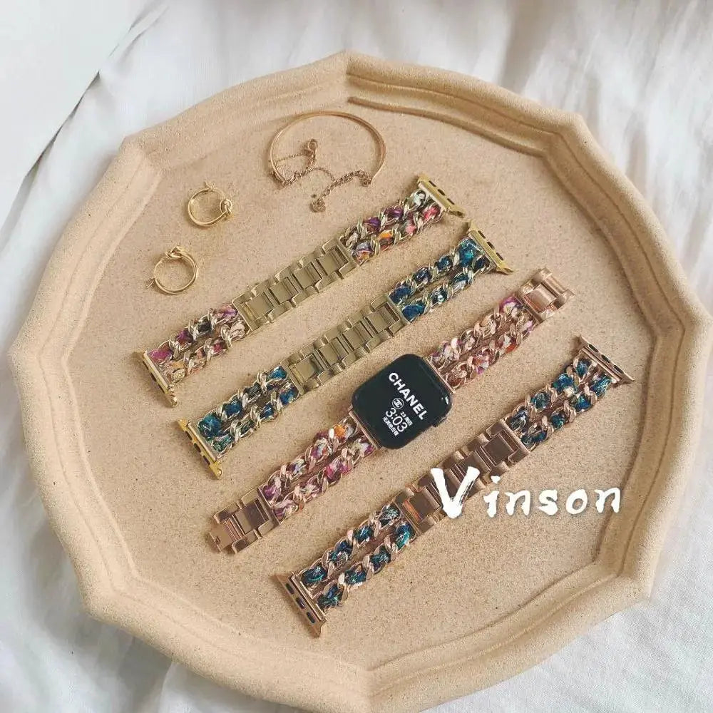 Luxury chunky bracelets with colorful accents, gold and rose gold finishes, and stylish earrings on a textured tray.