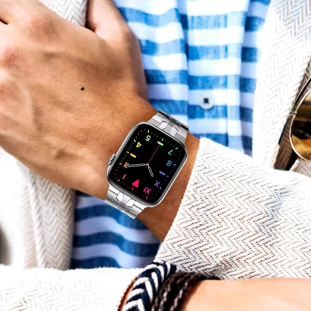 Luxury stainless steel bracelet worn on wrist with colorful watch face, showcasing style and modern design.