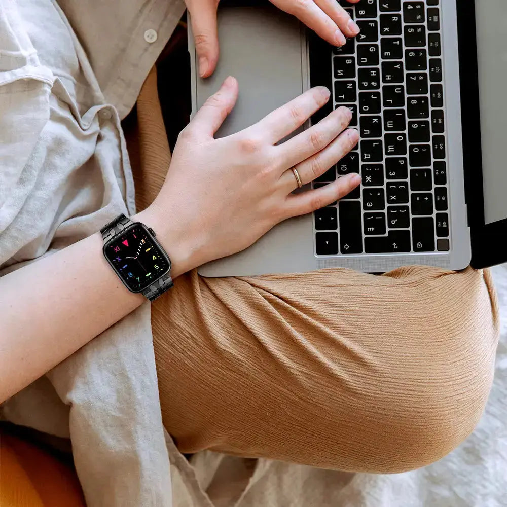 Luxury stainless steel bracelet on wrist while using a laptop, showcasing its stylish design and modern aesthetic.