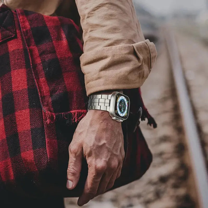Bold Titanium Bracelet worn with a rustic bag, showcasing a stylish rugged look on railway tracks.
