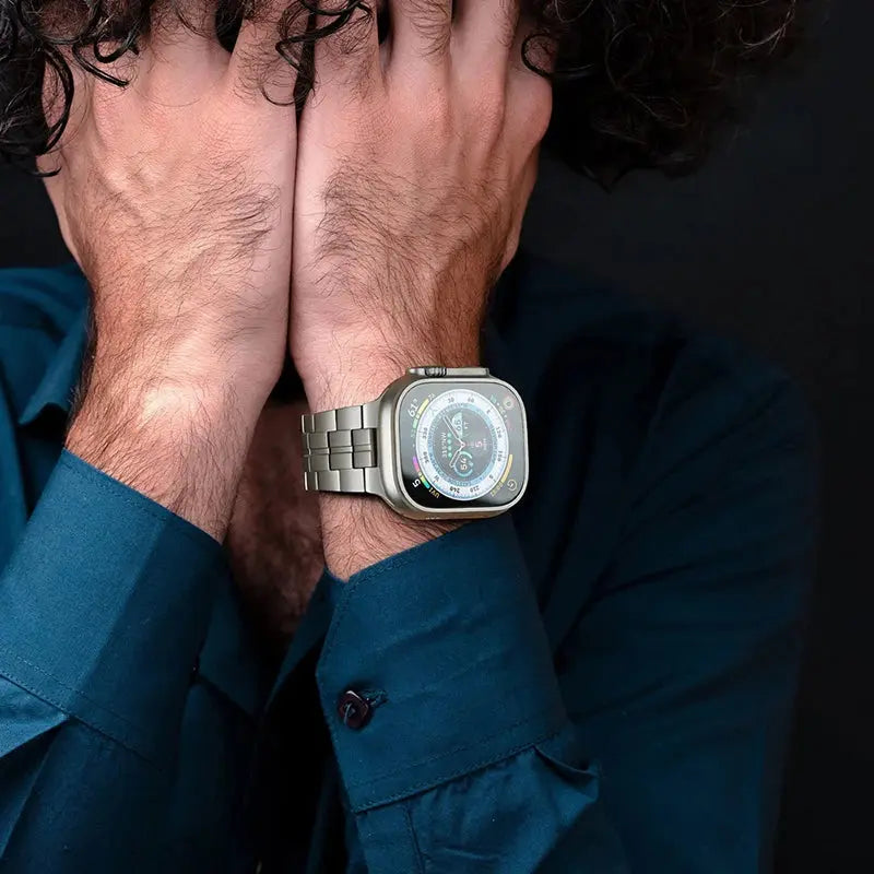Stylish man wearing a Bold Titanium Bracelet on an Apple Watch, showcasing strength and masculinity with a unique design.