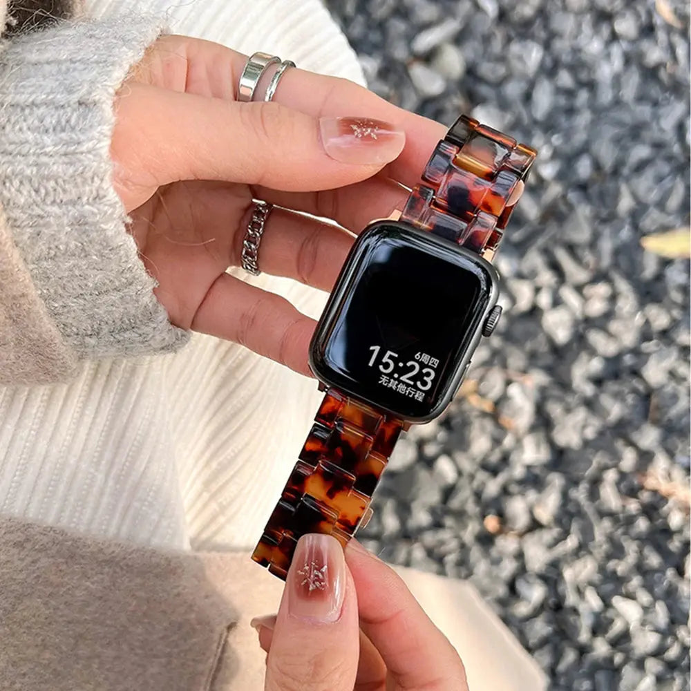 Hand wearing a Clear Slim Apple Watch Bracelet with a stylish tortoise pattern, showcasing its elegant design and comfort.