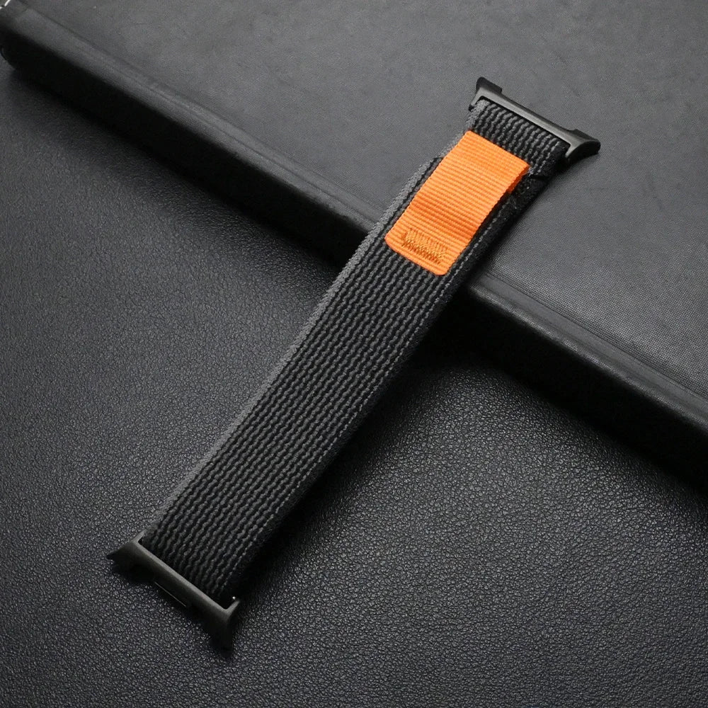 Travel Nylon Sport Loop Band for Galaxy Watch 8 & Ultra 47mm in black and orange on a dark background.