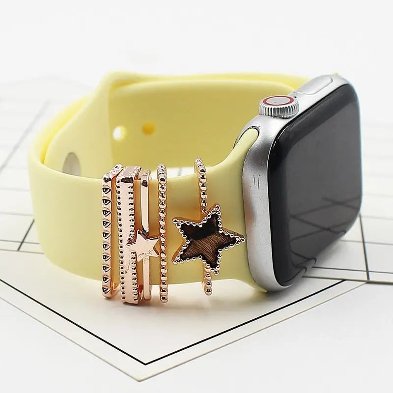Stylish yellow iWatch band adorned with rose gold decorative rings featuring star designs, enhancing elegance and sparkle.