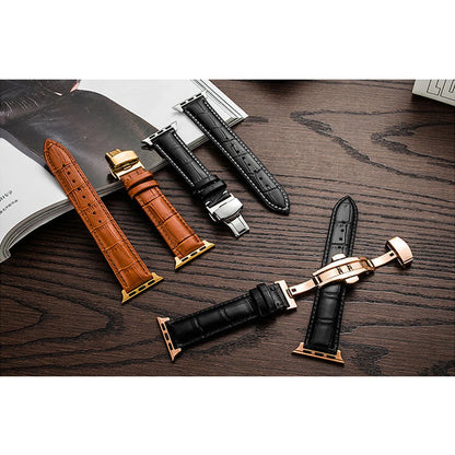 Luxury Crocodile Texture Leather Bands for Apple Watch displayed on a wooden surface with a book.