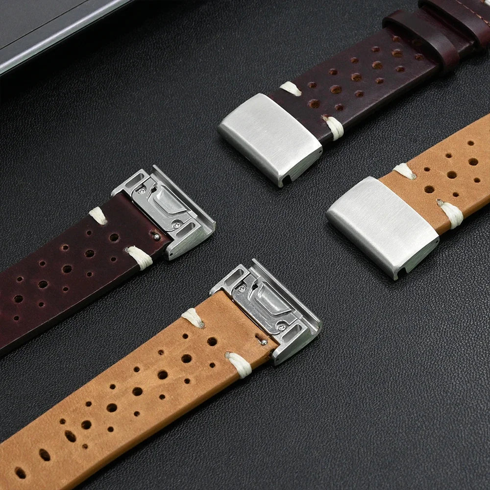 Two leather watch straps with metal buckles on a dark surface