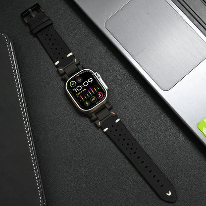 Stylish Armor Designed Leather Band for Apple Watch on a laptop, featuring high-quality metal connectors and breathable holes.