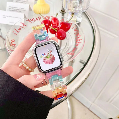 Clear Slim Acrylic Apple Watch Bracelet on wrist, showcasing a modern design and colorful band against a bright background.