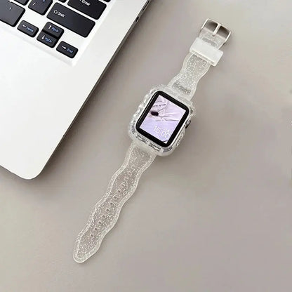 Crystal clear glittery silicone Apple Watch strap and case displayed on a desk near a laptop.