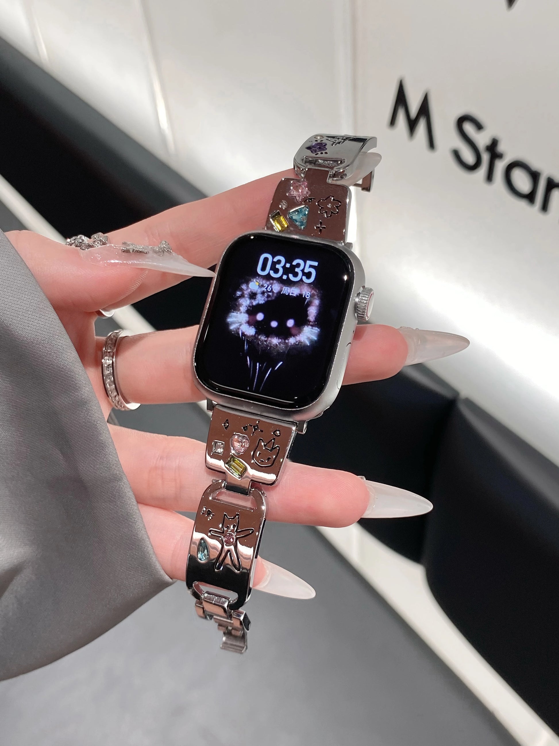 Cute Cat Jewelry Apple Watch Band – Glossy Metal Bracelet on a wrist with enamel cat designs and gem accents.