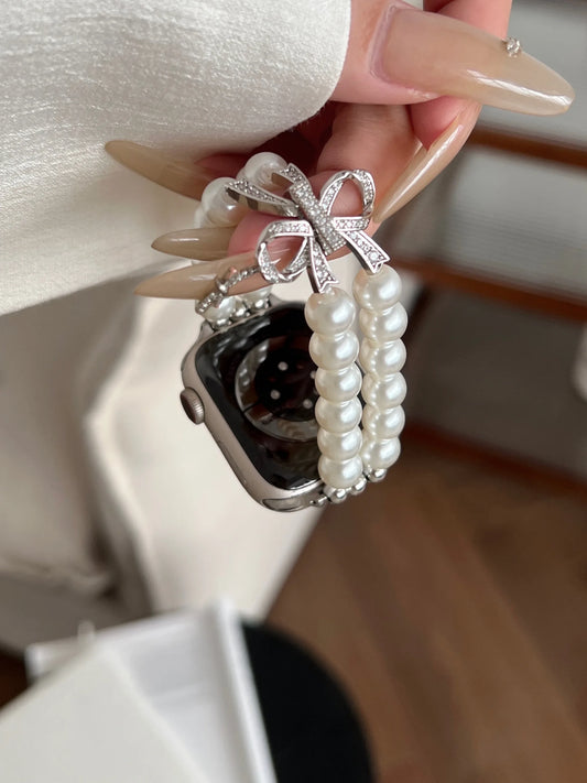 Luxury Pearl & Diamond Bow Apple Watch Band (38–49mm) featuring double-row pearl design and sparkling bow charm.
