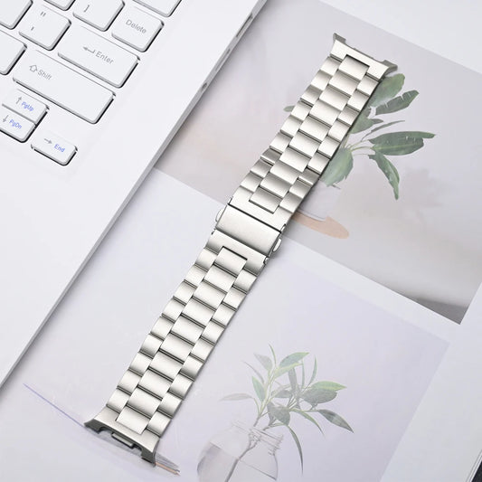 Luxury Stainless Steel Band for Galaxy Watch 8 & 8 Classic displayed on a table with a laptop and potted plant.