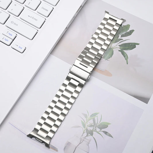 Luxury Stainless Steel Band for Galaxy Watch 8 & 8 Classic on a desk next to a laptop and plant images.