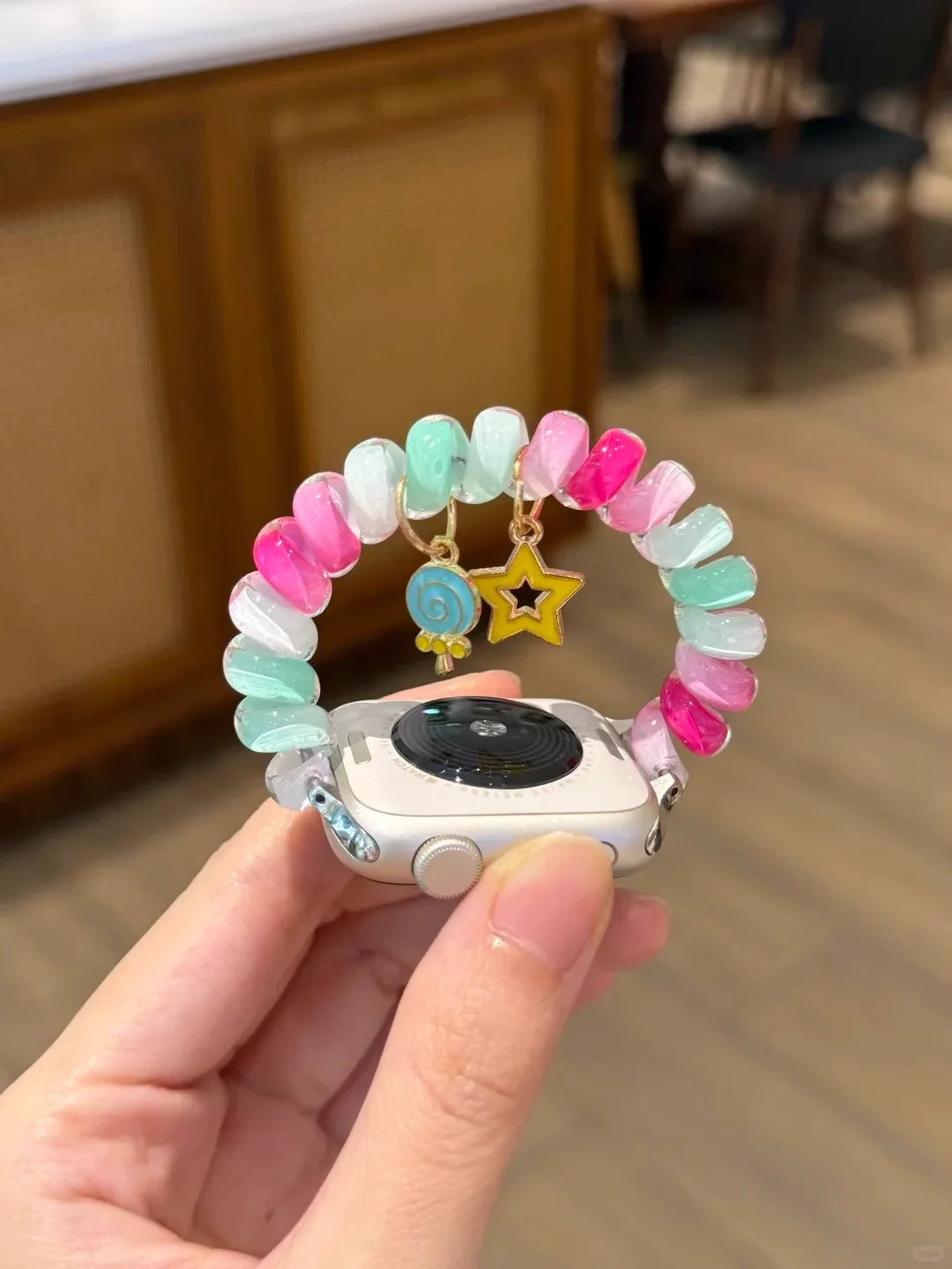 Rainbow Scrunchie Bracelet Apple Watch Band 38–49mm – Elastic Charm Strap on a hand with colorful beads and charms.