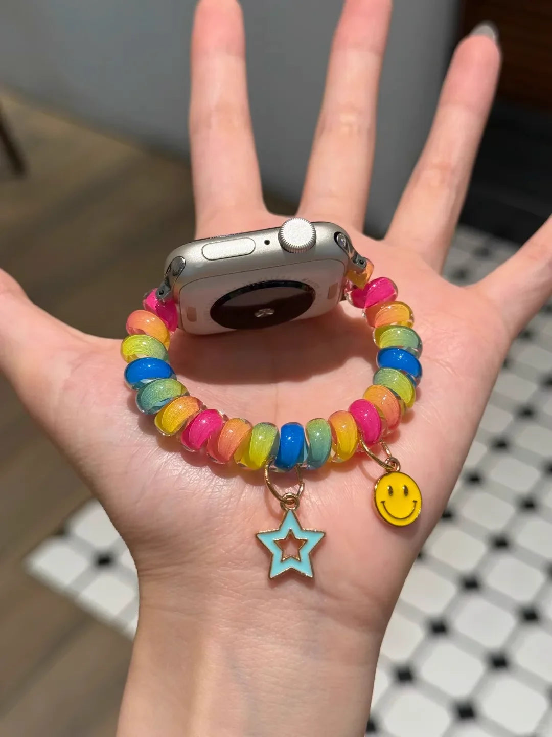 Rainbow Scrunchie Bracelet Apple Watch Band 38–49mm – Elastic Charm Strap on a hand with colorful beads and charms.