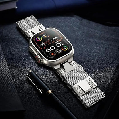 Stylish Alpha Loop Apple Watch band with Milanese Loop design on a desk with a pen, showcasing sophistication and technology.