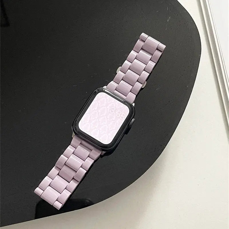 Sleek light purple acrylic Apple Watch bracelet with a black watch face on a modern surface.