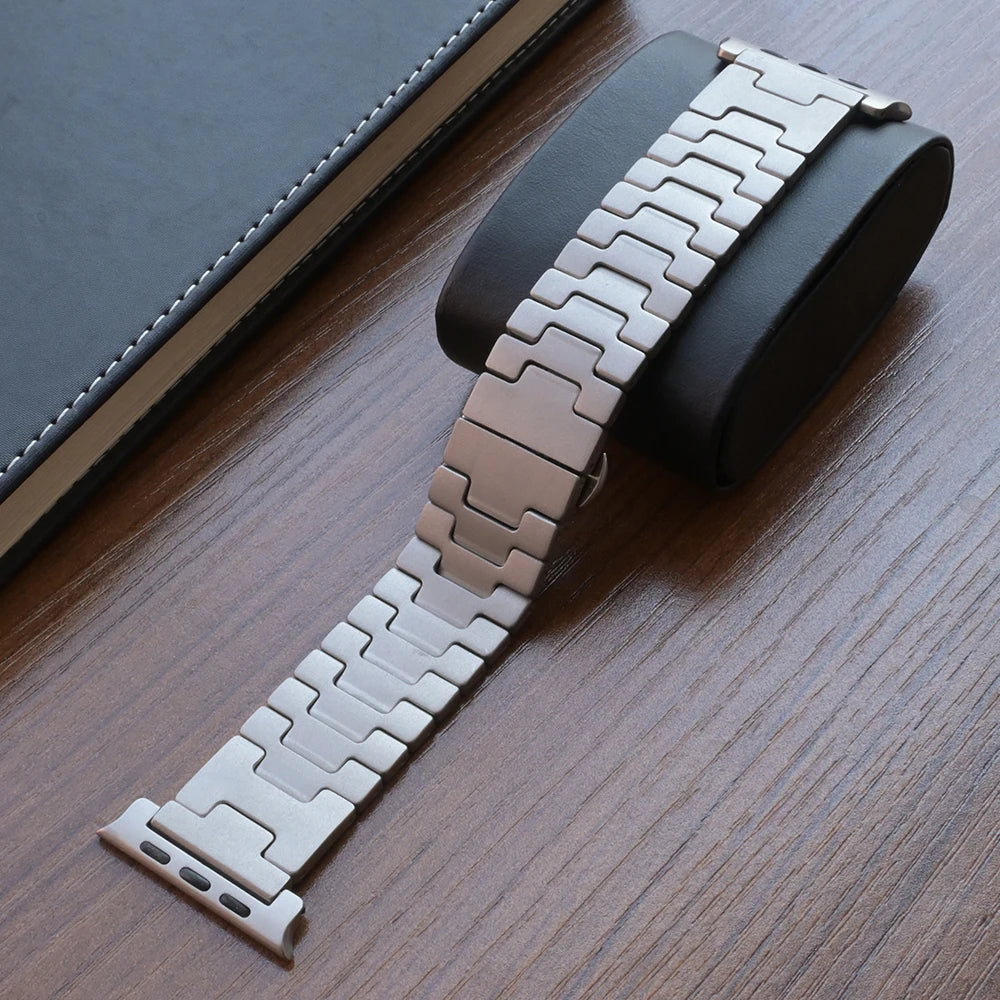 Titanium Apple Watch Band Ultra 3/Series 11/SE – Luxury Bracelet on display next to a black cushion.