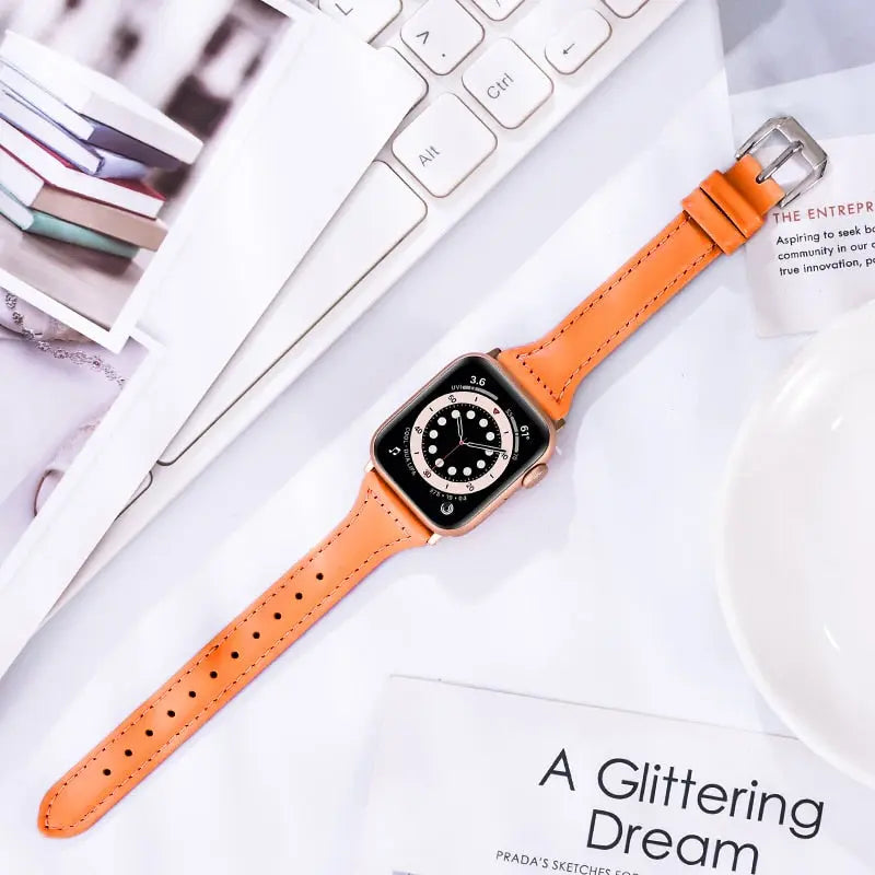 Slim leather band for Apple Watch in orange, soft texture, durable stainless steel connectors, stylish accessory.